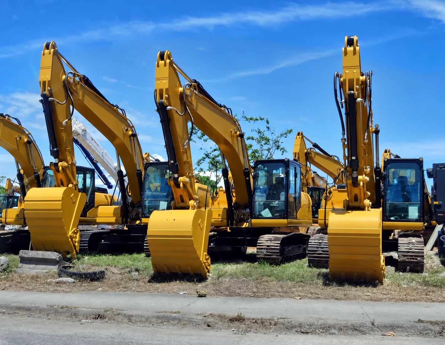 Construction machinery lined up in a yard.