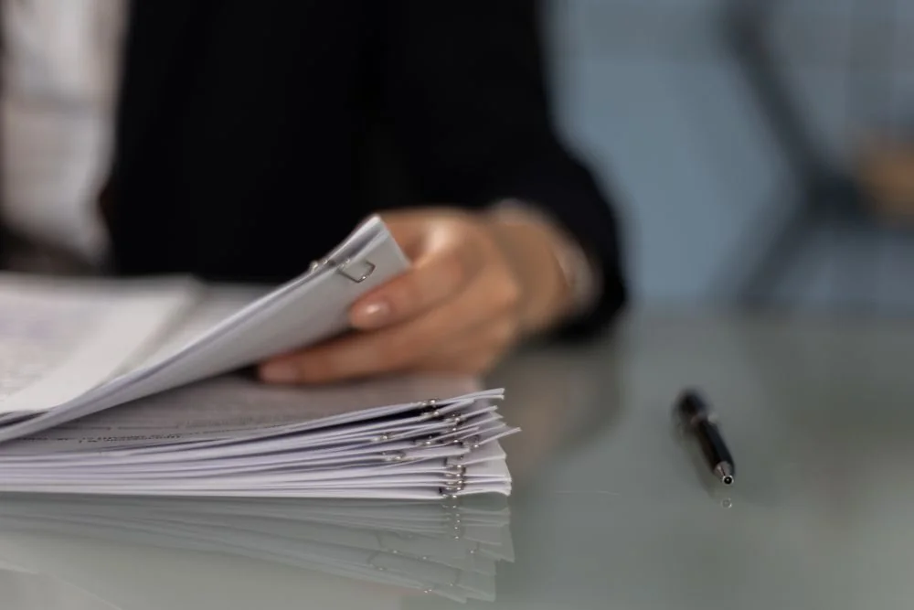 Reviewing a stack of documents held with paper clips.