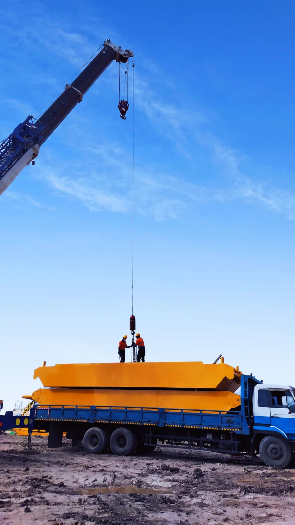 Loading a large component onto a truck with a crane.